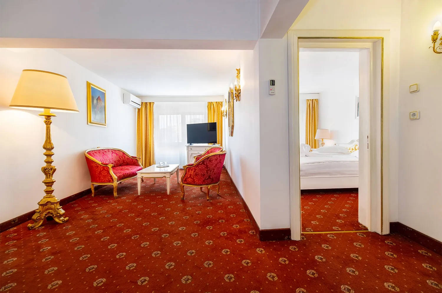 Salonul Apartamentului Superior cu canapele clasice și acces spre dormitor